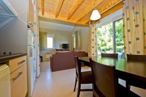 - une cuisine et une salle à manger avec une table et des chaises dans l'établissement Résidence Goélia Les Cottages du Lac, à Coly