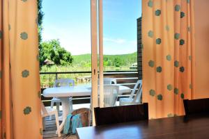 a balcony with a table and chairs and a window at Résidence Goélia Les Cottages du Lac in Coly +12 photos