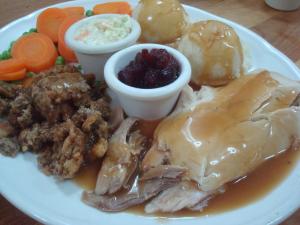 a plate of food with meat and vegetables on a table at Sherbrooke Village Inn in Sherbrooke