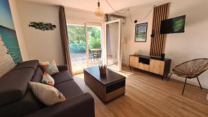 a living room with a couch and a tv and a table at Les Studios de Fiori - Studios et Appartement T2 - Cala Rossa - proche Porto Vecchio in Lecci +41 photos