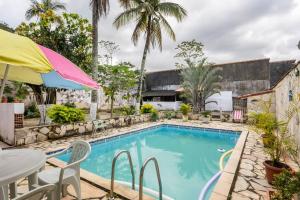 uma piscina com uma mesa e um guarda-sol em Espaço Ideal de Itaipuaçú em Maricá