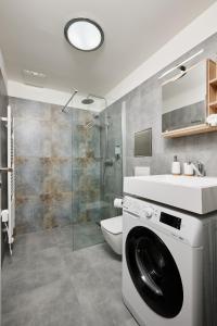 a bathroom with a washing machine and a sink at Residence 44 in Prague