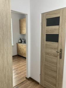 a wooden door in a room with a kitchen at Apartament w Centrum Malborka in Malbork