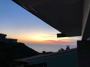 a view of the ocean at sunset from a house at Oasi del Relax - Seaside Peaceful Panoramic Terrace in ITALY - new Sardinia apartment 50 mt beach&sea full comfort air conditioning-WiFi-Parking-Privacy in Torre Dei Corsari