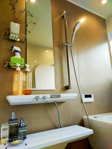 eine Dusche im Bad mit Waschbecken und Spiegel in der Unterkunft Open House Sakurasakura - Kamakurayama - - Vacation STAY 14047 in Kamakura