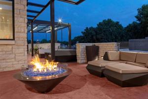 eine Terrasse mit einer Feuerstelle mit einem Sofa und einem Tisch in der Unterkunft SpringHill Suites by Marriott Kansas City Plaza in Kansas City
