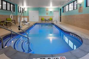 - une grande piscine d'eau bleue dans un bâtiment dans l'établissement SpringHill Suites by Marriott Kansas City Plaza, à Kansas City