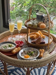 a table with plates of food and glasses of orange juice at HOTEL NUU CHIANG MAI in Chiang Mai
