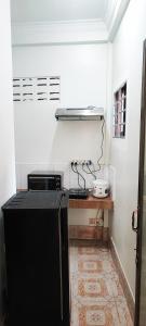 uma cozinha com um frigorífico preto num quarto em Secret Garden Homestay em Siem Reap