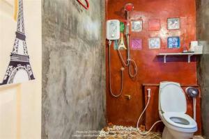 a bathroom with a toilet and a painting of the eiffel tower at Na-Rak-O Resort in Chiang Rai