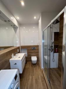 y baño con aseo, lavabo y ducha. en I&M Apartments Sikorskiego Wrocław, en Wroclaw