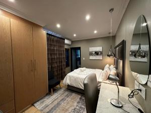 1 dormitorio con cama y escritorio. en Urban Villas Guest House, en Pretoria