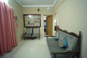 Pallipuram的住宿－EDEN BEACH VILLA，客厅配有沙发和墙上的时钟
