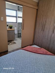 a bedroom with a sliding door and a bathroom at 2FiftySix on Second in Lüderitz