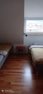 a room with two beds and a red table at Apartment na Gruszy in Stronie Śląskie