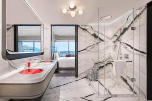 bagno con vasca, lavandino e specchio di W Xiamen-Next to shopping center&Exhibition Center a Xiamen