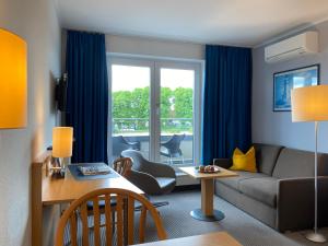 a living room with a couch and a table at Hotel Stadthafen Stade in Stade