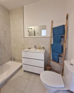 ein Badezimmer mit einem WC, einem Waschbecken und einer Badewanne in der Unterkunft L'Ancien Poste in Sénergues