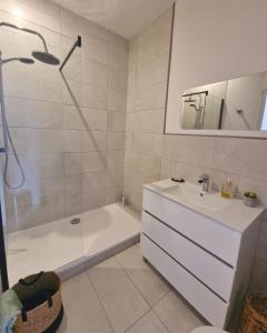 ein Bad mit einer Badewanne, einem Waschbecken und einer Dusche in der Unterkunft L'Ancien Poste in Sénergues