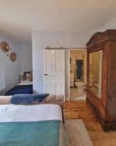 ein Schlafzimmer mit einem Bett und einer Kommode sowie ein Badezimmer in der Unterkunft L'Ancien Poste in Sénergues