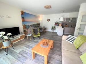 ein Wohnzimmer mit einem Sofa und einem Tisch in der Unterkunft Ferienwohnung Dünenhopser in Rostock