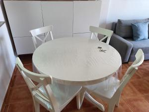 een witte tafel met 2 stoelen en een bank bij Apartamento Palomares in Cuevas del Almanzora