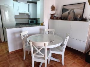 een keuken met een witte tafel en stoelen bij Apartamento Palomares in Cuevas del Almanzora