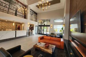 a living room with an orange couch and a table at La Quinta by Wyndham San Francisco Airport West in Millbrae