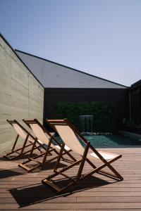 three lounge chairs sitting on a deck next to a pool at Geonature in Macedo de Cavaleiros