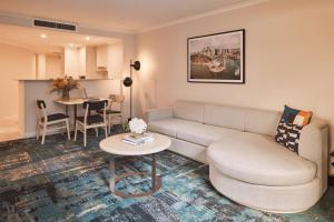 a living room with a couch and a table at Rydges Darling Square Apartment Hotel in Sydney