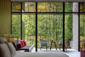 - un salon avec une grande fenêtre et un canapé dans l'établissement Garrya Nijo Castle Kyoto - Banyan Group, à Kyoto
