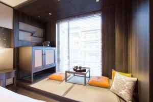 a bedroom with a bed and a table and a window at Dhawa Yura Kyoto in Kyoto