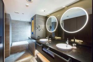 a bathroom with two sinks and two mirrors at Dhawa Yura Kyoto in Kyoto