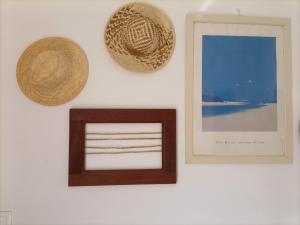 uma parede branca com uma foto e um chapéu de palha em Babo Lanzarote em Playa Blanca