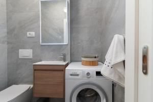 a bathroom with a washing machine and a sink at Apartment New Bridge Trogir in Trogir