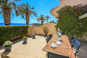 a patio with two tables and palm trees and the ocean at Porto Fino Litoral - ONLY FAMILIES in Miami Platja