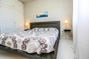 ミアミ・プラトーヤにあるPorto Fino Litoral - ONLY FAMILIESのベッドルーム1室(ブラウンと白の掛け布団付きのベッド1台付)