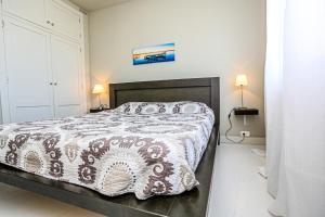 a bedroom with a bed with a brown and white comforter at Porto Fino Litoral - ONLY FAMILIES in Miami Platja