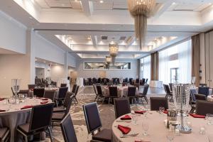 a banquet hall with tables and chairs and a chandelier at Residence Inn by Marriott New York Long Island East End in Riverhead