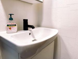 a bathroom sink with a bottle of soap on it at Cozy apartment in Klaksvík in Klaksvík