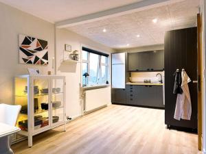 a kitchen with black cabinets and a counter top at Cozy apartment in Klaksvík in Klaksvík