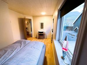 a bedroom with a bed and a large window at Cozy apartment in Klaksvík in Klaksvík