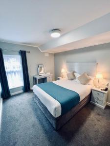 a bedroom with a large bed and a large window at Beresford Hotel in Dublin