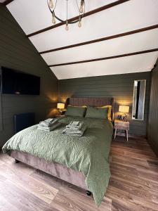 a bedroom with a large bed with a white ceiling at The Cabin Near Stansted Airport in Little Hallingbury