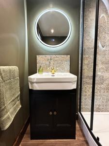 a bathroom with a sink and a mirror at The Cabin Near Stansted Airport in Little Hallingbury