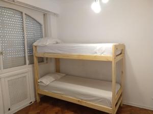 Cette chambre comprend 2 lits superposés et une fenêtre. dans l'établissement las cañitas libertador, à Buenos Aires
