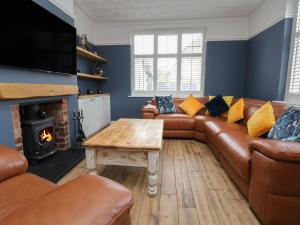 a living room with a leather couch and a table at Bryn Gwynedd in Conwy