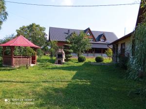 a house with a red roof and a gazebo at Kosmatska pusanka in Kozmacz
