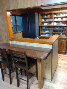 a kitchen with a wooden table and chairs at Momiji hostel in Minami Aso