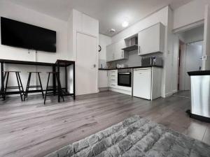 a large kitchen with white cabinets and a table in it at Modern Central 5 Bed Apartment in Liverpool